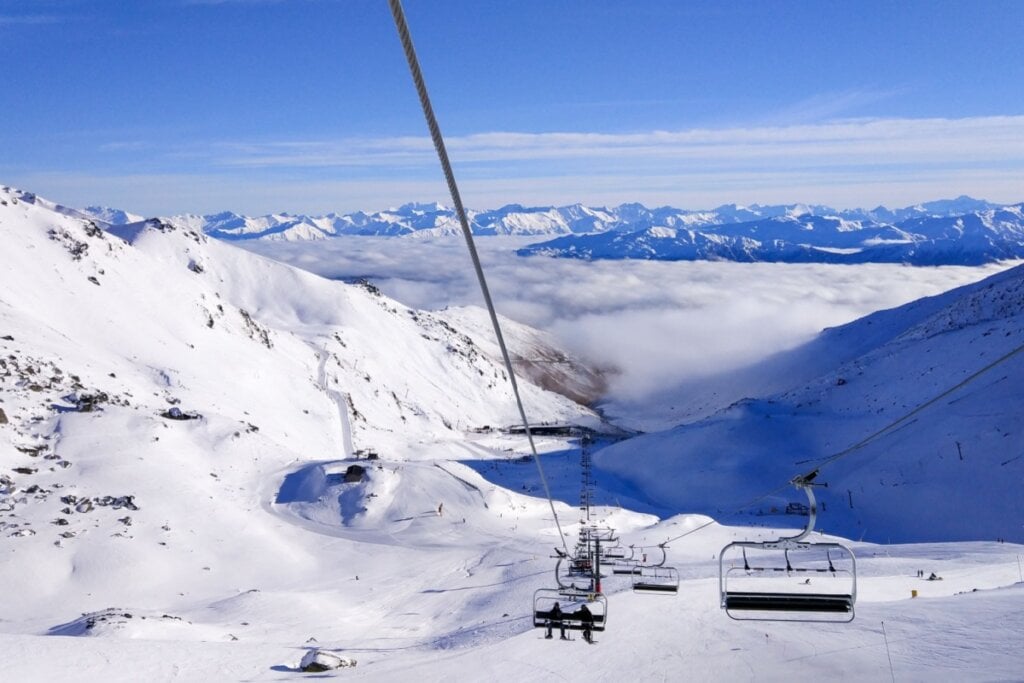 Imagem de montanha com muita neve e teleférico