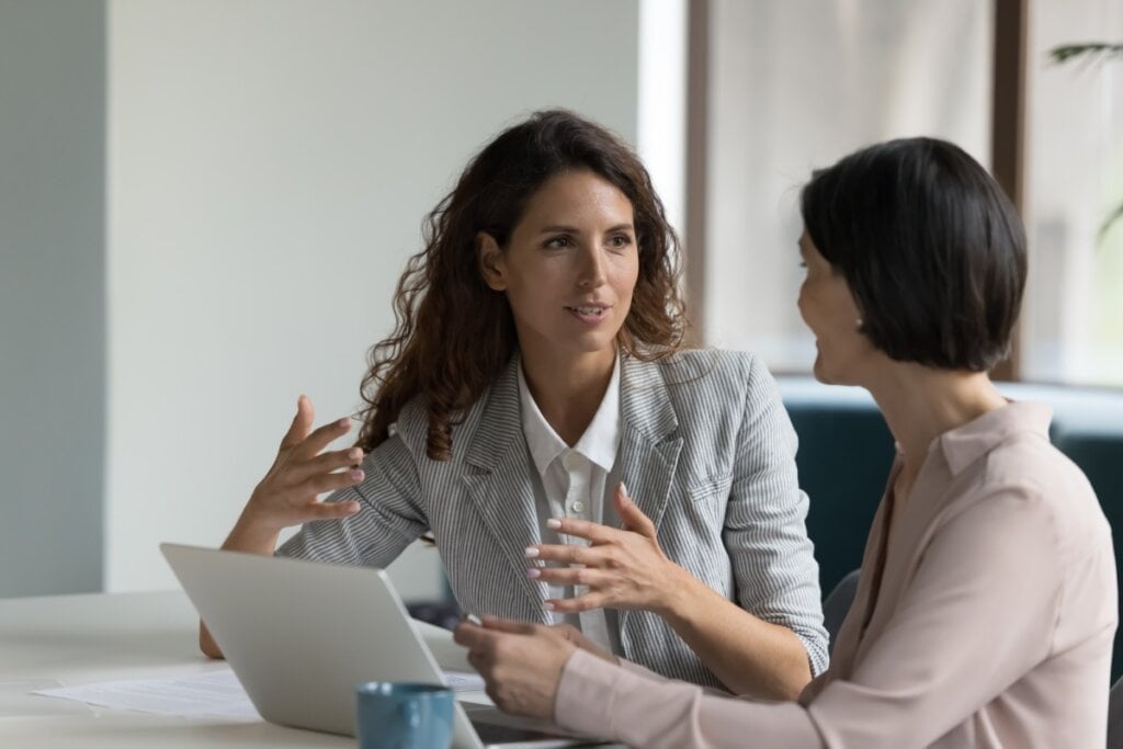 Duas mulheres sentadas em um escritório conversando 