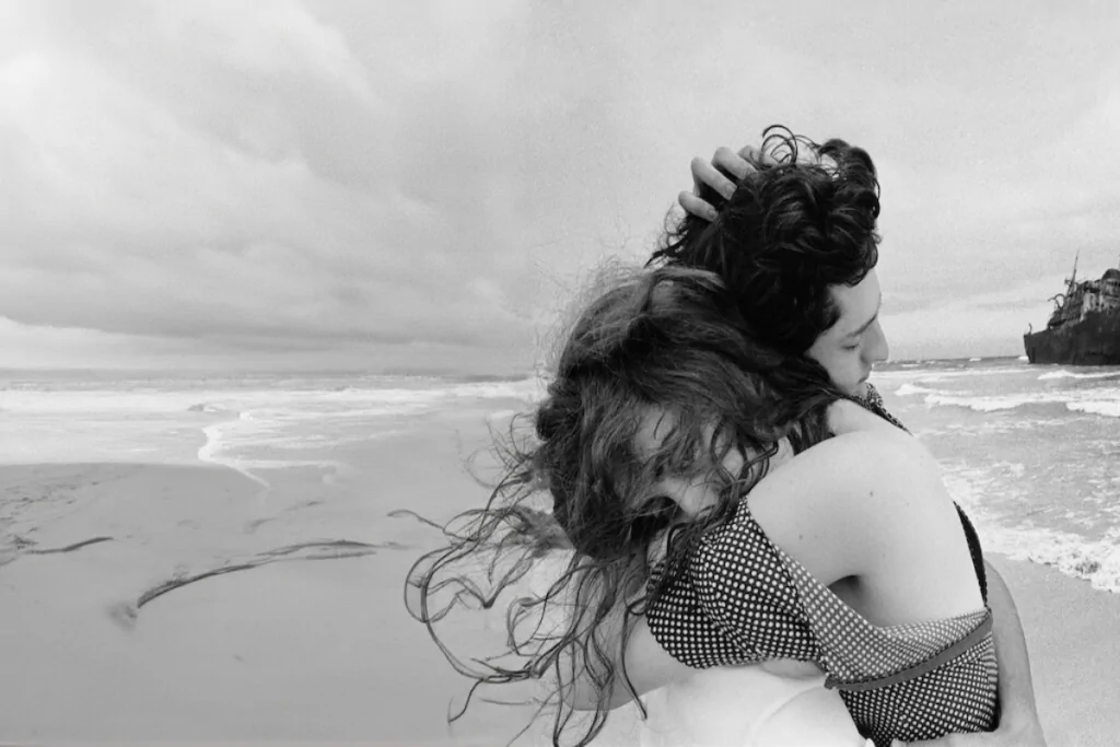 Imagem de casal abraçado em preto e branco na praia 