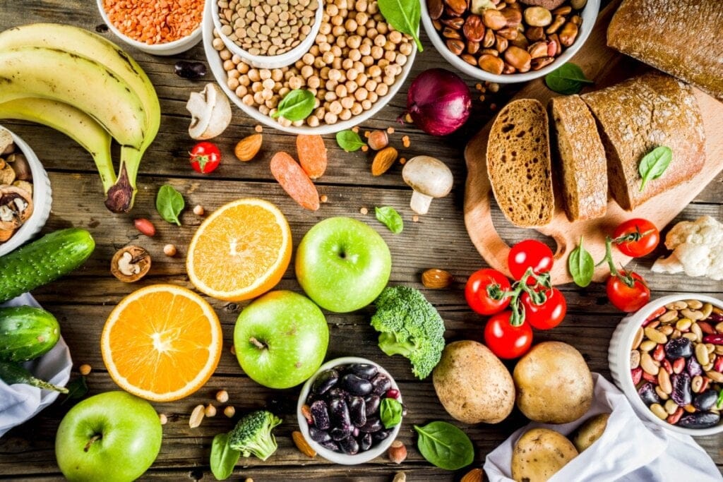 Mesa de madeira com frutas, vegetais e grãos integrais