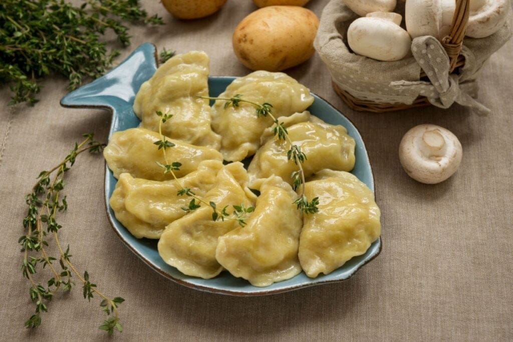 Bolinhos recheados de cogumelo e batata em travessa azul com formato de peixe