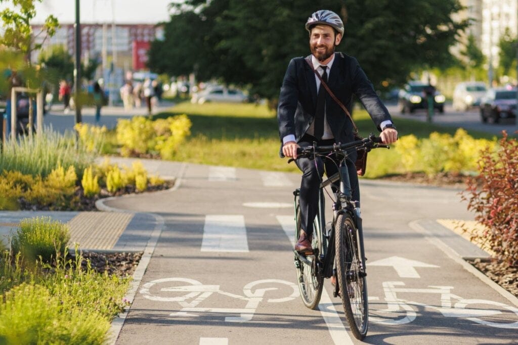 Homem vestindo terno e andando de bicicleta na rua