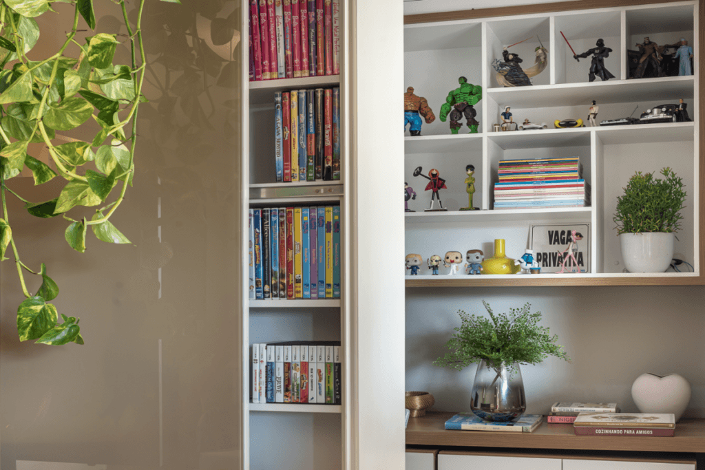 Móvel com compartimento para objetos decorativos e ao fundo uma prateleira com nichos e objetos decorativos