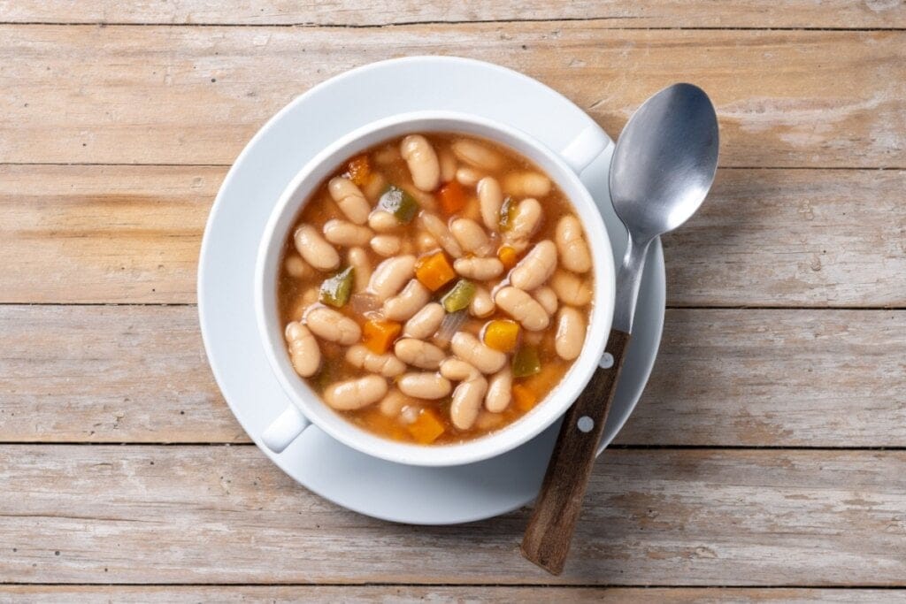 Sopa para preservar a massa magra em um prato branco ao lado de uma colher