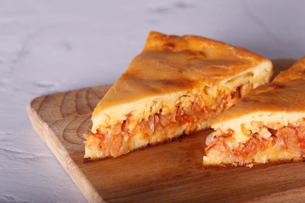 Tábua de madeira com dois pedaços de torta vegana de repolho