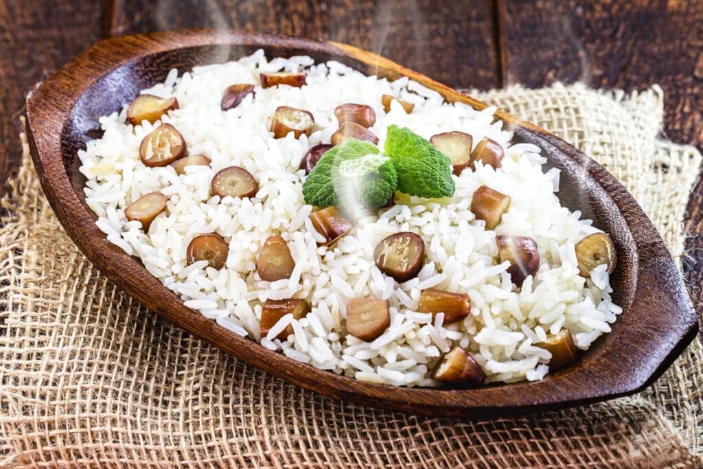 Recipiente marrom com arroz e pinhão 