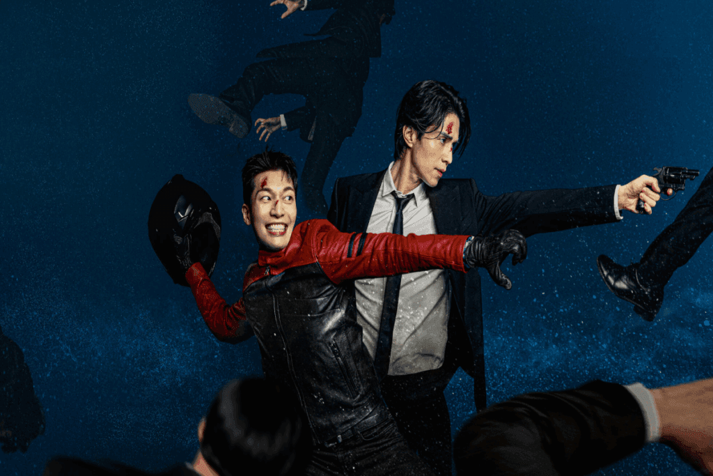 Imagem de dois homens lutando, um está com uma roupa social, e o outro com uma roupa de motoqueiro com um capacete na mão 