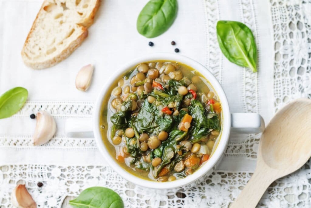 Sopa de lentilha servida em uma cumbuca de porcelana branca