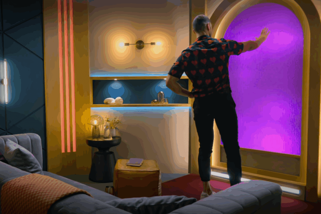 Homem toca uma porta iluminada em tons de roxo em um cenário moderno com luzes quentes e móveis