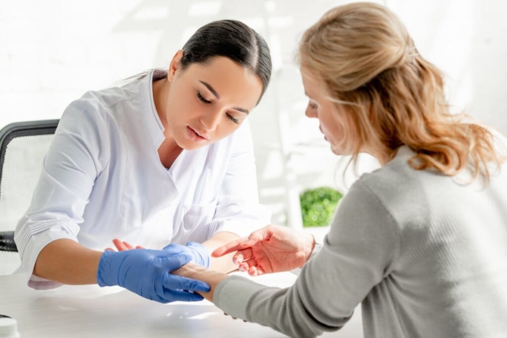 Médica olhando braço de paciente