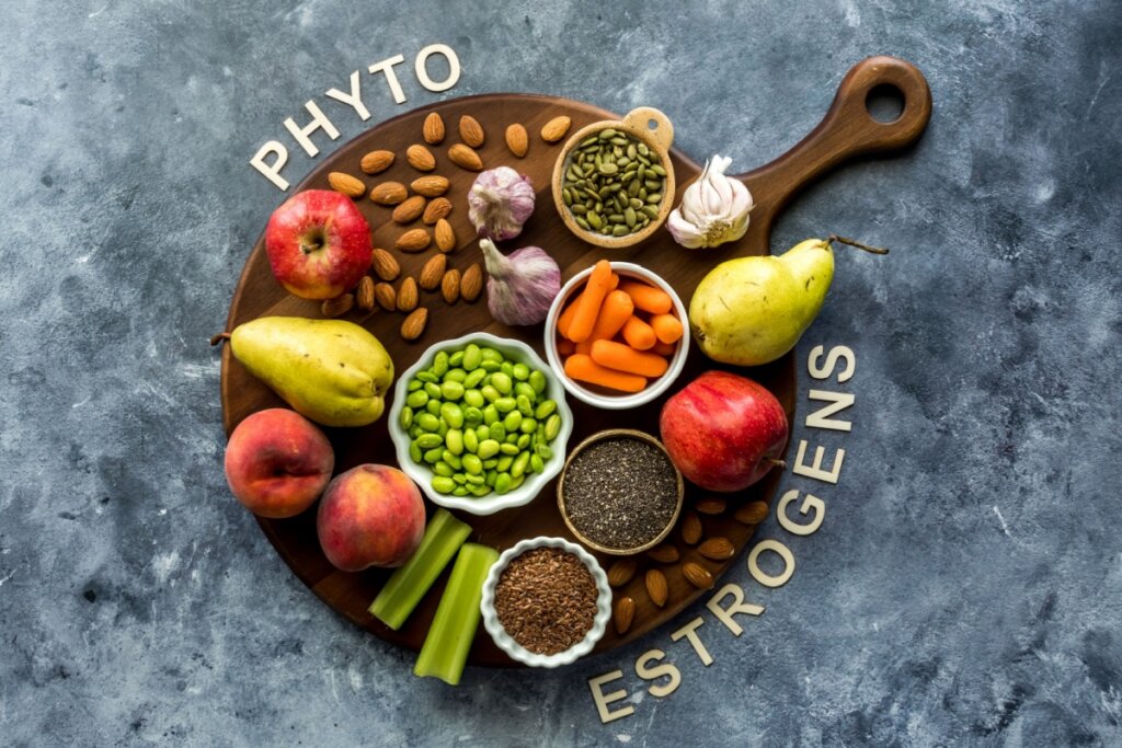 Tábua de madeira com alimentos ricos em  fitoestrógenos como linhaça pera, alho e ao redor está escrito fitoestrógenos em inglês