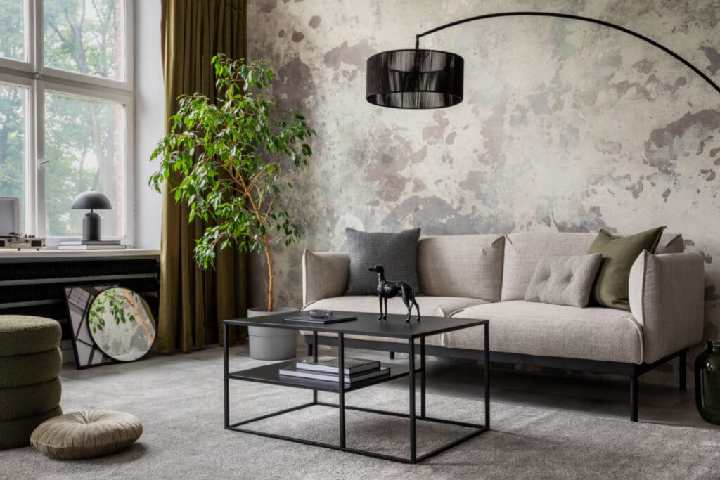 Sala de estar com decoração minimalista e industrial, sofá bege, mesa de centro preta e janela lateral