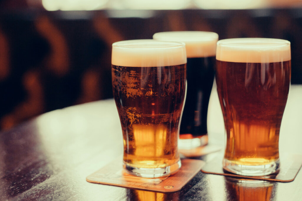 copos de vidro com cerveja em cima do balcão