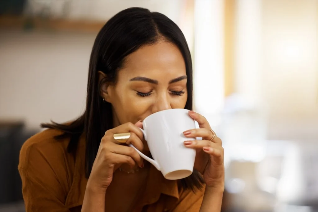 Mulher bebendo chá em caneca branca