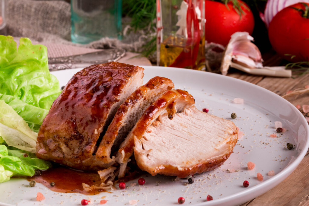 Lombo em cima de uma travessa branca com folhas de alface