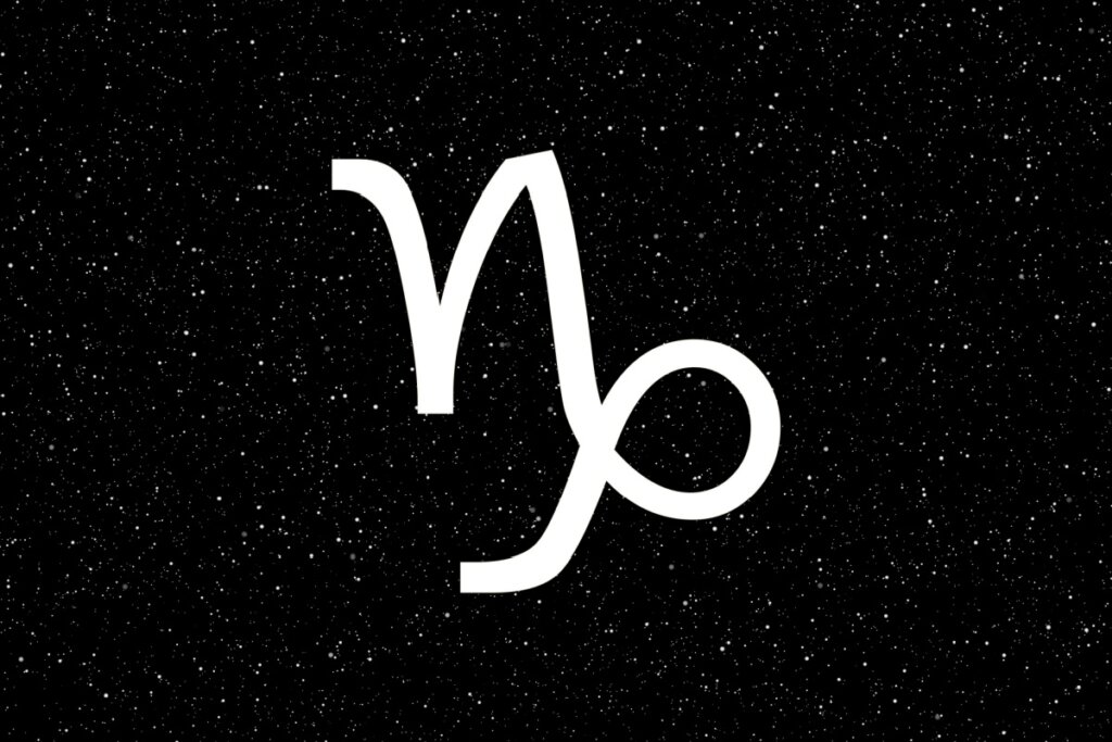 Símbolo de Capricórnio com textura de galáxia azul e efeito de vidro, com linhas que formam um "V" curvado, sobre um fundo de céu noturno azul-escuro profundo e estrelado.