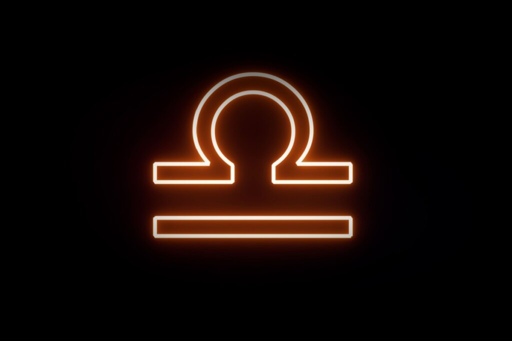Ilustração digital do símbolo de Libra (uma linha superior curva sobre uma linha horizontal reta, representando uma balança). O símbolo apresenta um contorno brilhante em neon laranja e branco contra um fundo preto.
