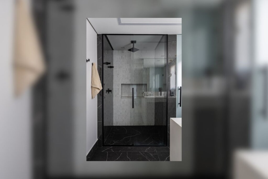 Banheiro com box padrão preto e paredes brancas 