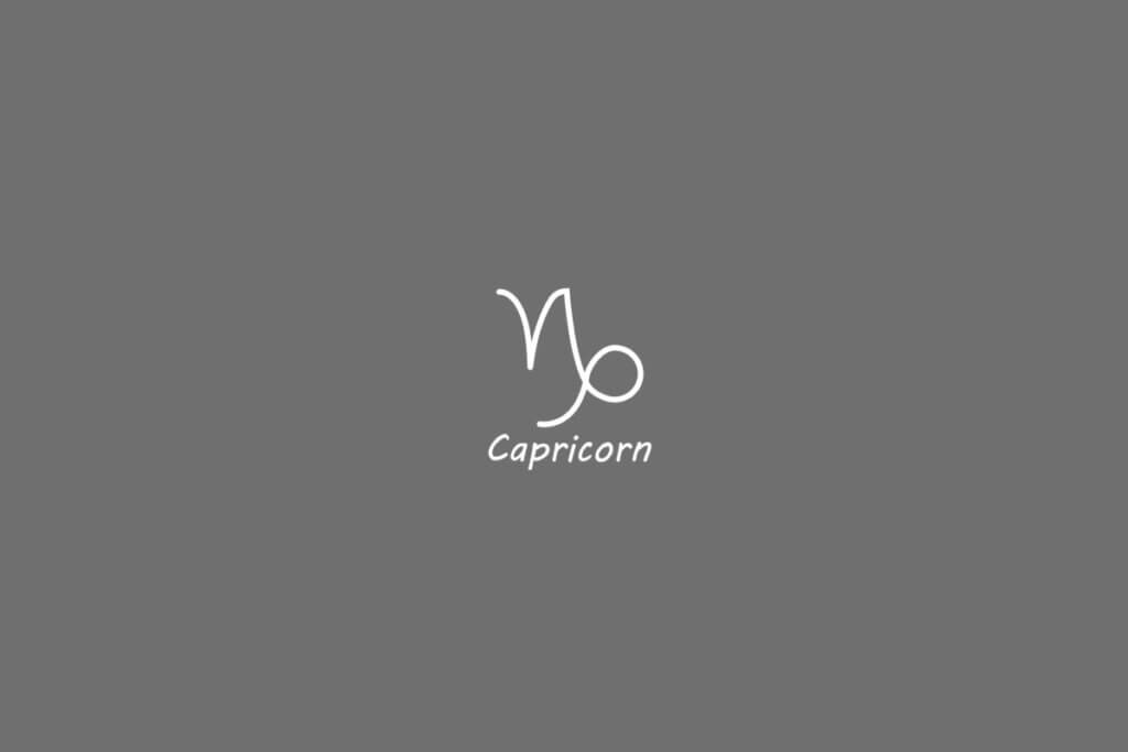 Símbolo do signo de capricórnio, na cor banca, centralizado em um fundo cinza e com o nome embaixo