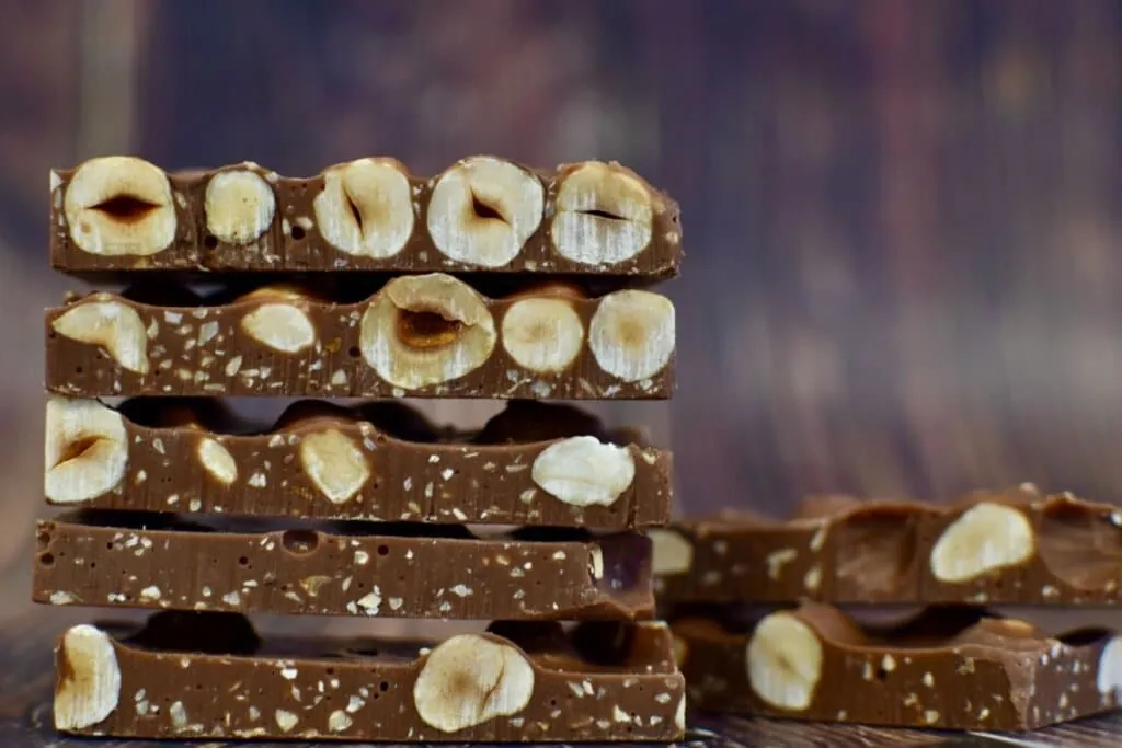 Pedaços cortados de barras de chocolate com amêndoas caramelizadas