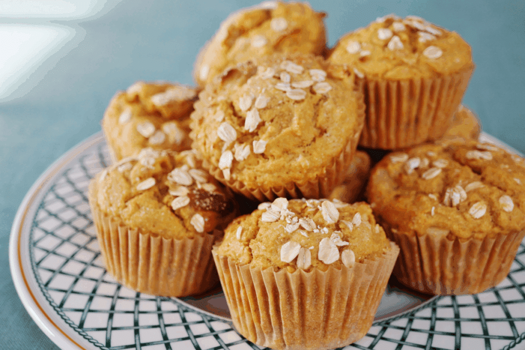 Muffin de aveia com nozes servido em prato de cerâmica estampado em cima de bancada azul