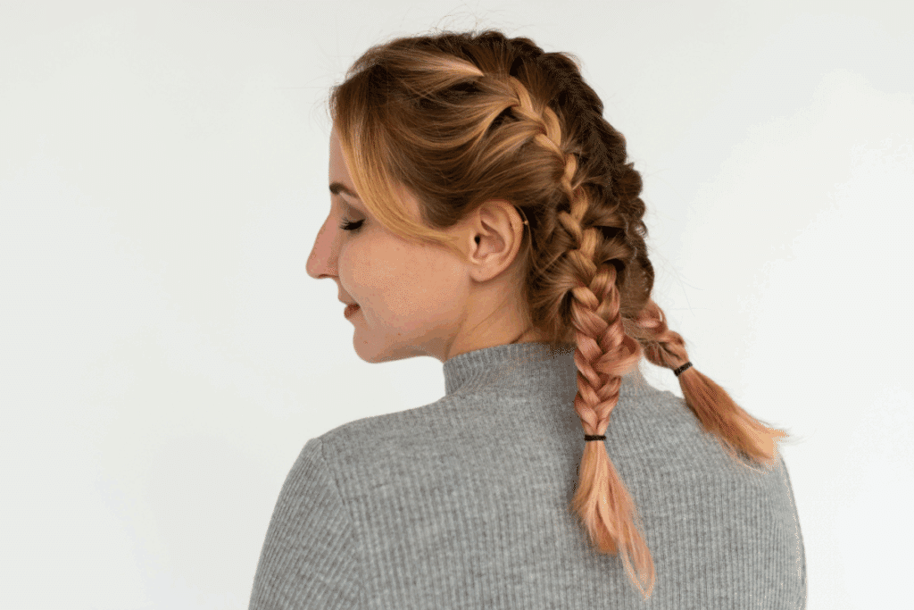 Mulher com o rosto virado de lado e cabelo com tranças embutidas nas laterais 