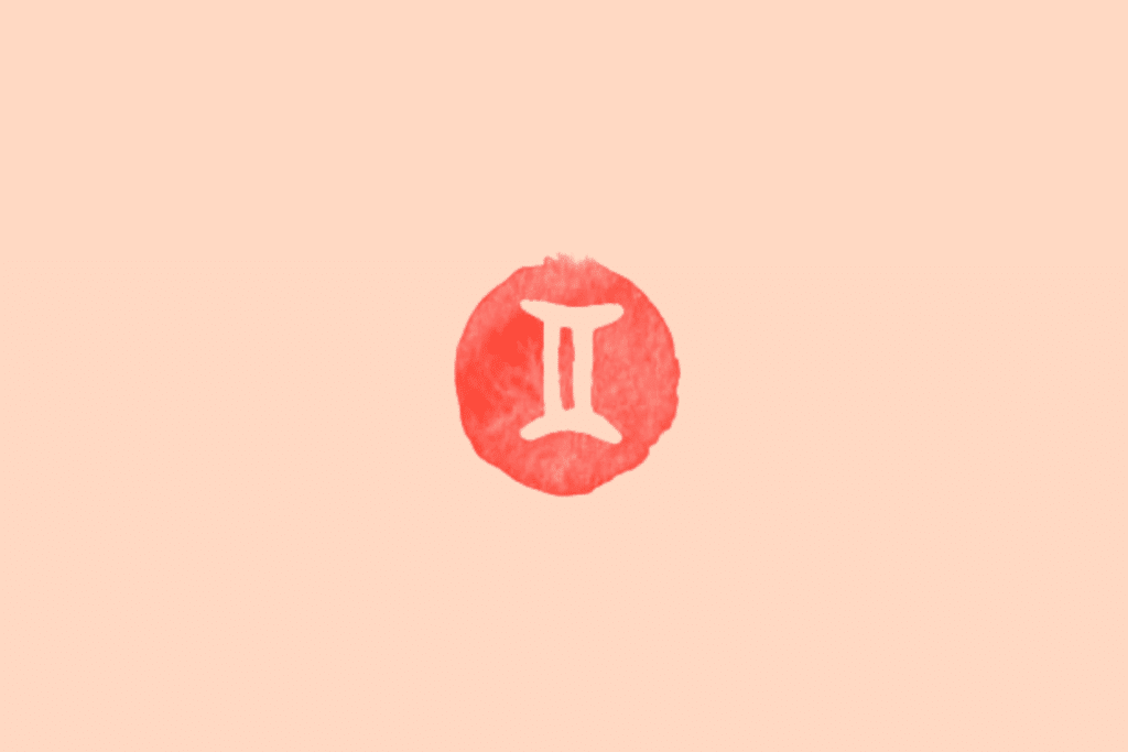 Ilustração do signo de Gêmeos sobre fundo uniforme em tom pêssego-claro. No centro, há um círculo irregular em vermelho-coral, com textura de aquarela e contornos levemente desiguais. O símbolo de Gêmeos, em tom creme, apresenta duas linhas verticais paralelas, unidas por traços curvos na parte superior e inferior, formando uma figura semelhante ao numeral romano II.