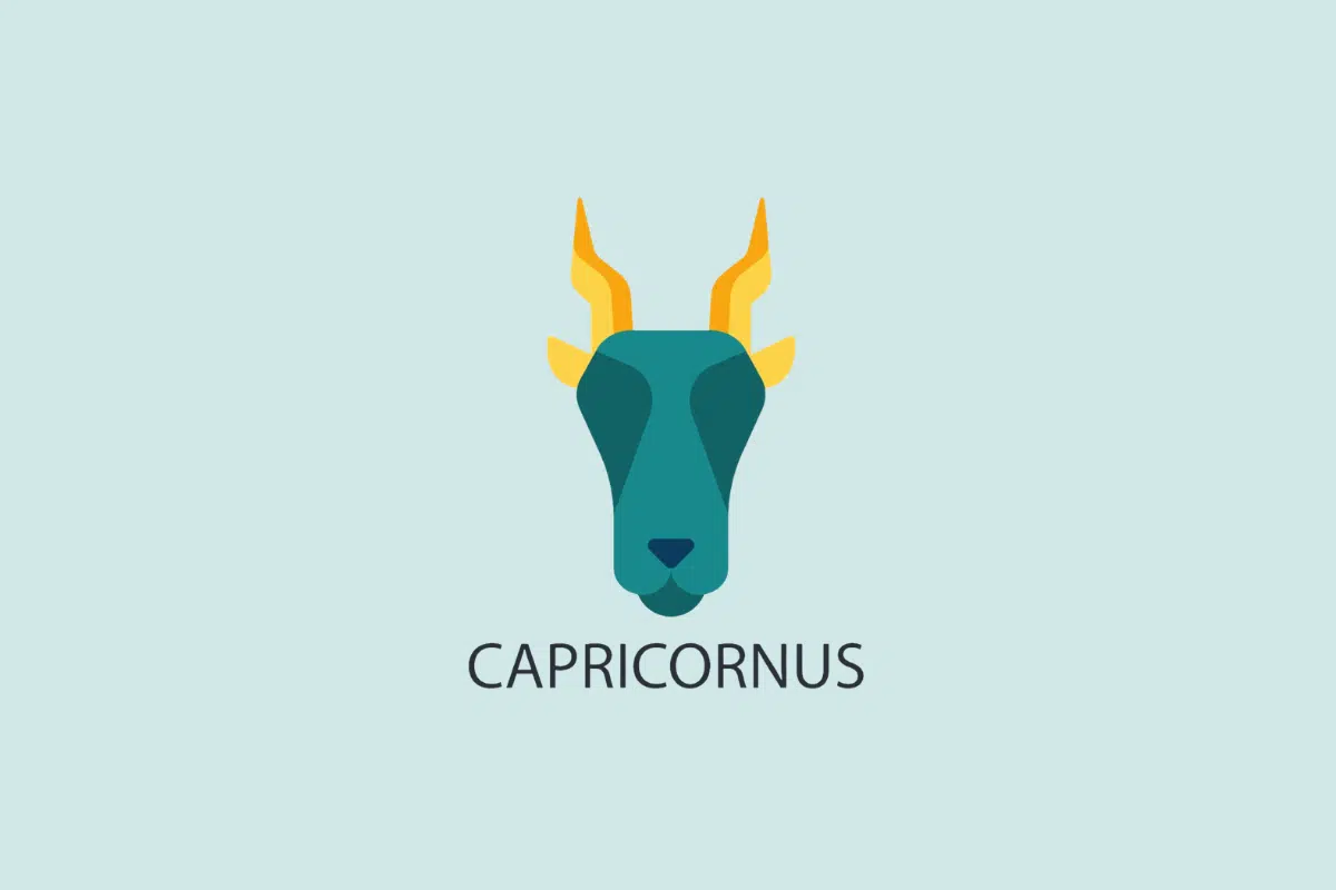 Ilustração vetorial em estilo plano da cabeça de um bode com chifres amarelos e pontiagudos, sobre um fundo azul-claro com a palavra "CAPRICORNUS" escrita abaixo.